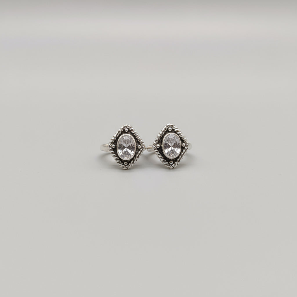 A pair of silver toe rings with a shimmering surface