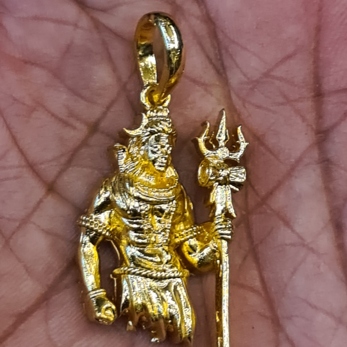 Panchaloham Lord Shiva pendant held in hand showing gold finish, trishul and intricate deity detailing
