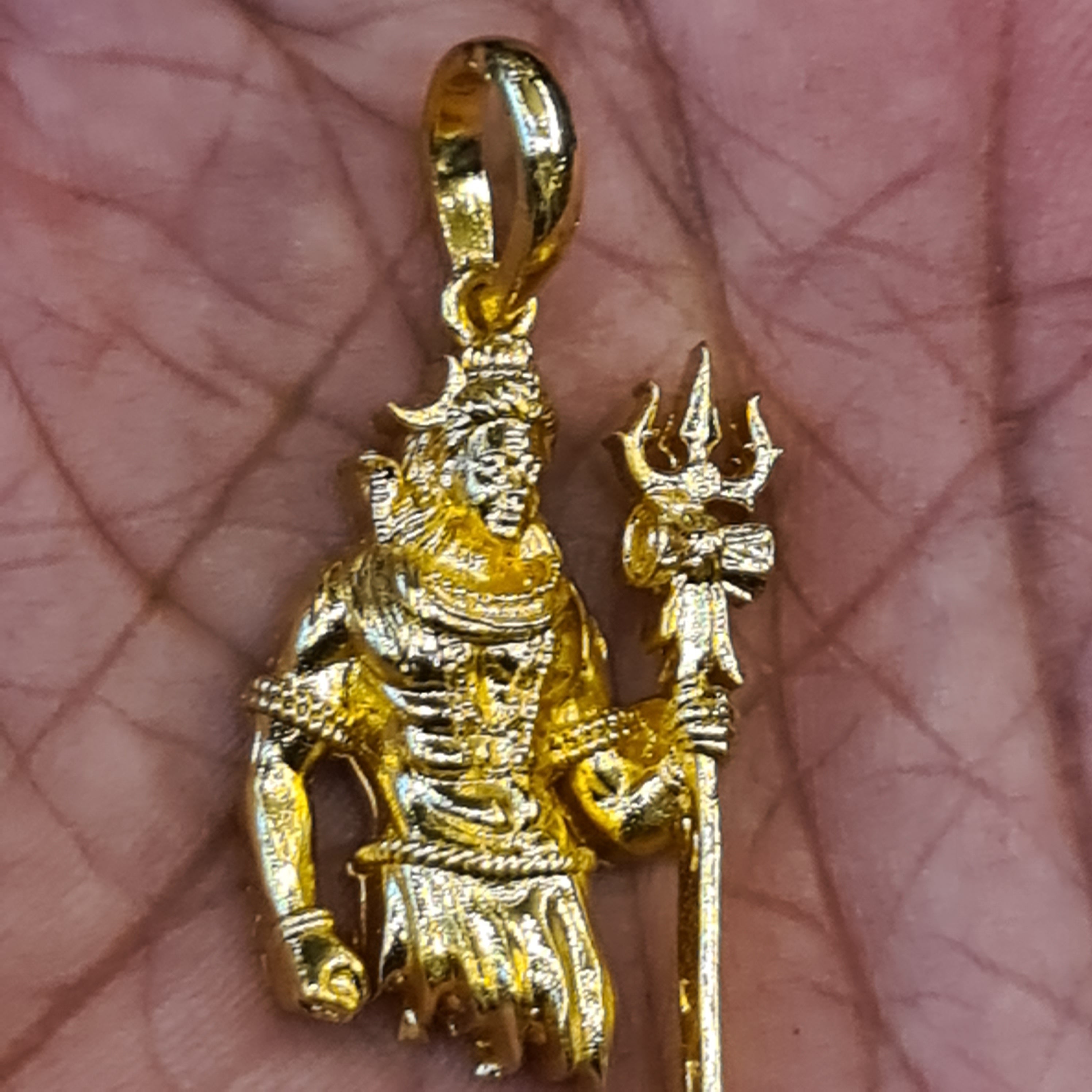 Panchaloham Lord Shiva pendant held in hand showing gold finish, trishul and intricate deity detailing