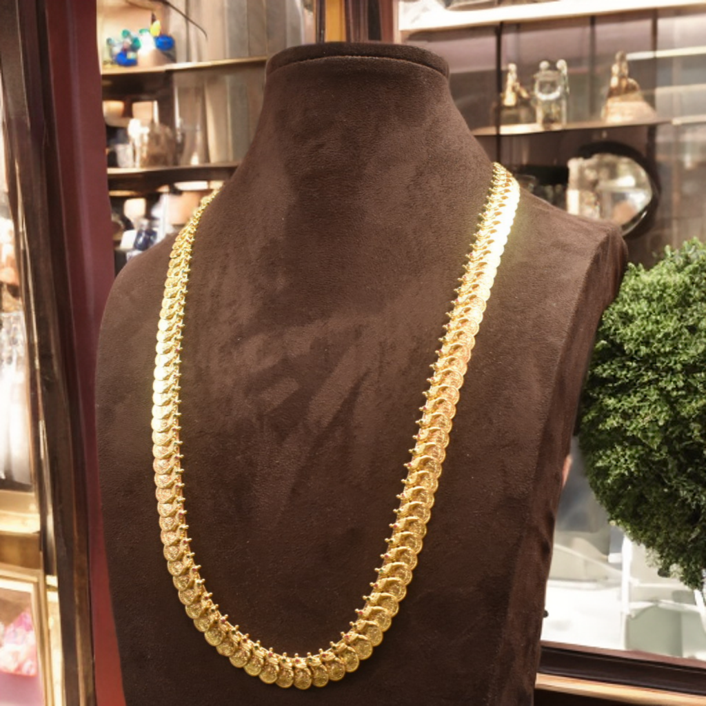 Gold necklace on a mannequin bust with a blurred indoor background