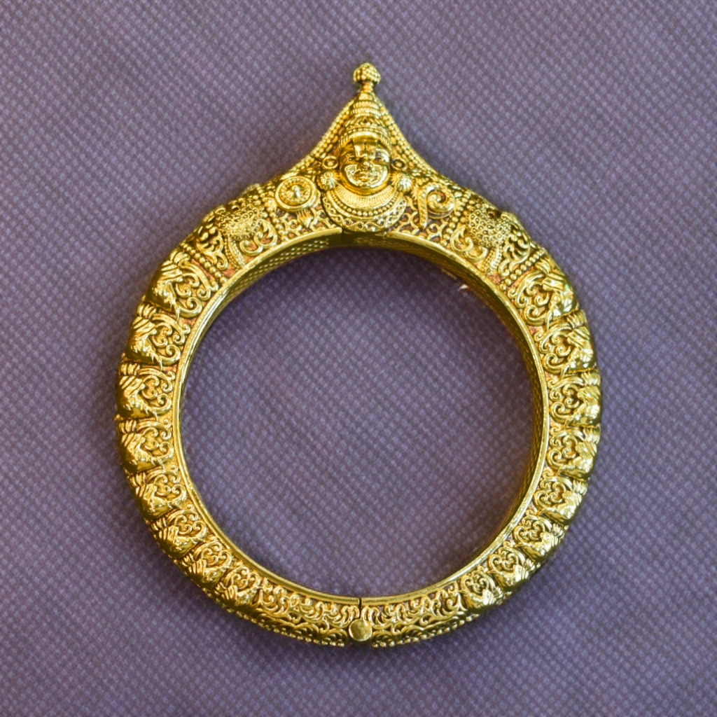 Decorative gold ring with intricate designs on a purple background