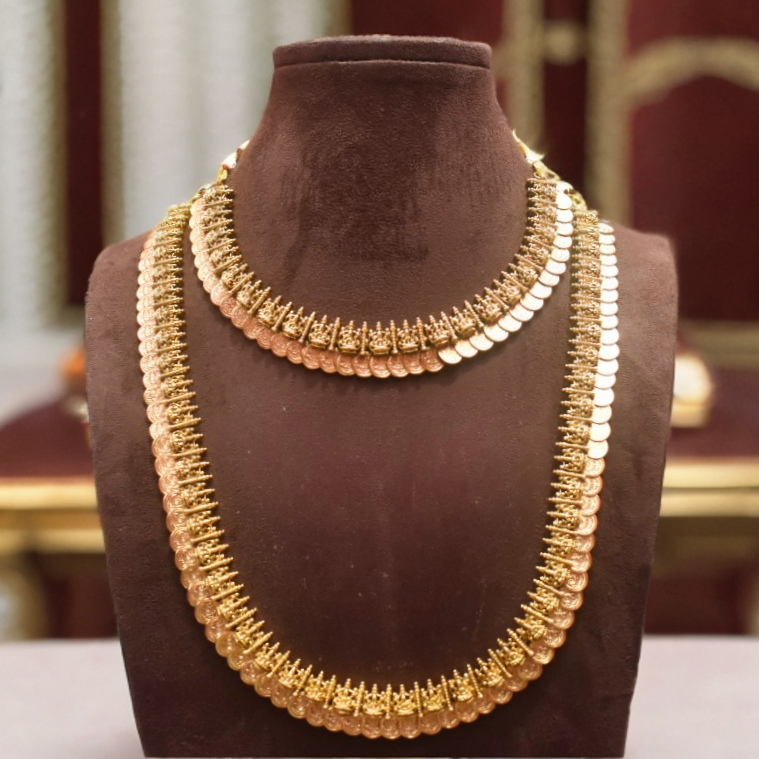 Gold necklace on a brown velvet mannequin bust with a blurred background
