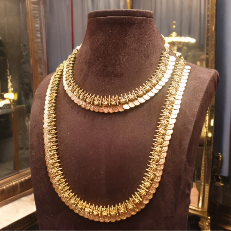 Gold necklace on a brown mannequin bust with a reflective background