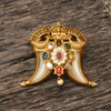 Decorative gold brooch with gemstones on a wooden surface