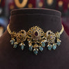 Ornate gold and turquoise necklace on a dark brown mannequin