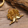 Gold lion head brooch with gemstones on a wooden surface