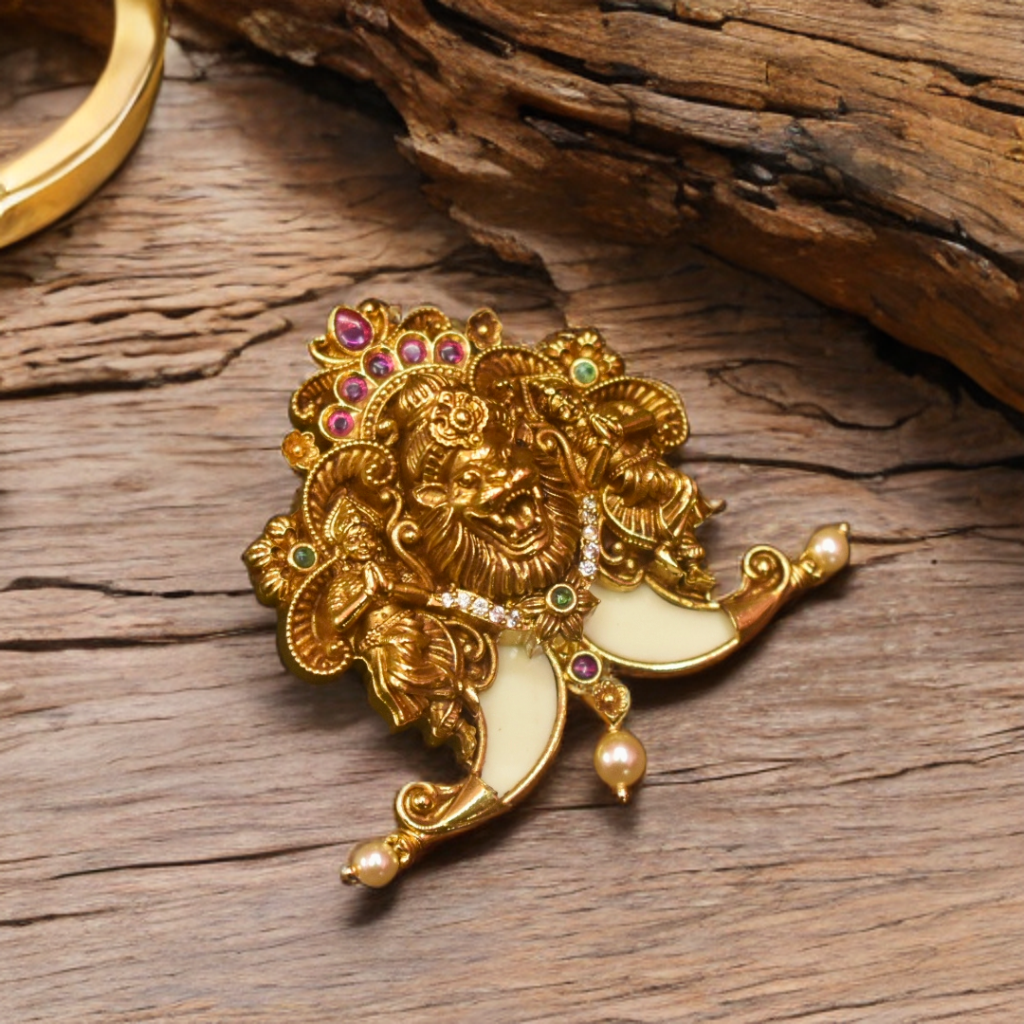 Gold lion head brooch with gemstones on a wooden surface