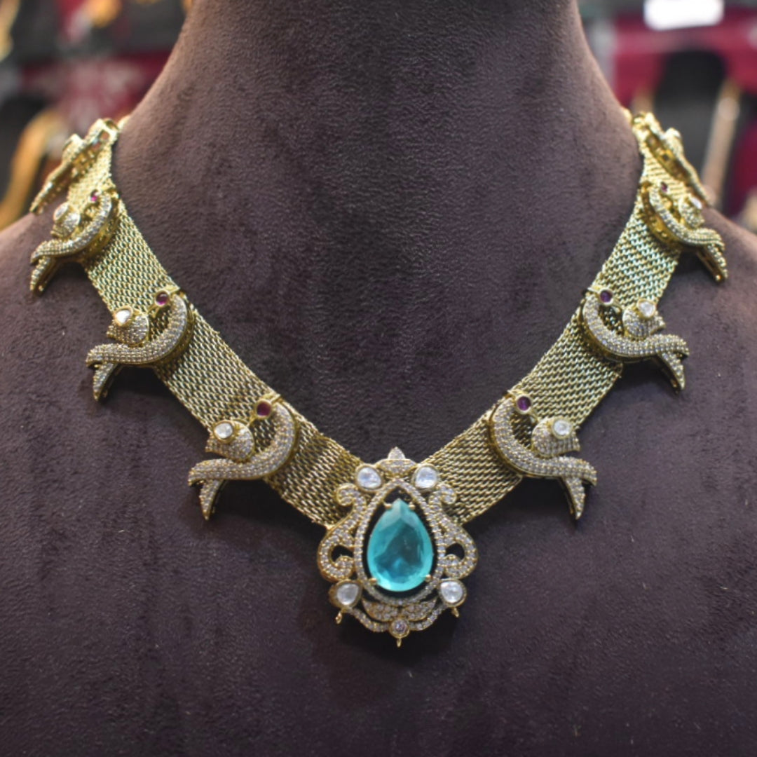 Gold necklace with a blue gemstone on a mannequin