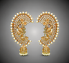 Pair of ornate gold earrings with pearls on a gray background
