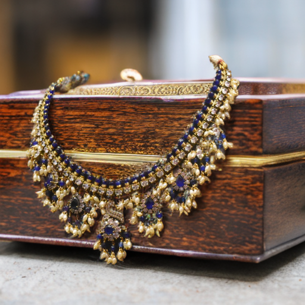 Ornate necklace with blue stones on a wooden box