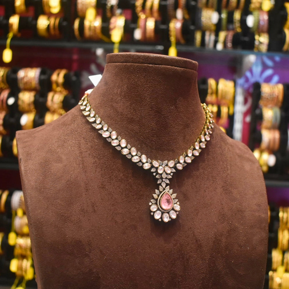 Jewelry necklace on a brown mannequin with a blurred background of other jewelry.