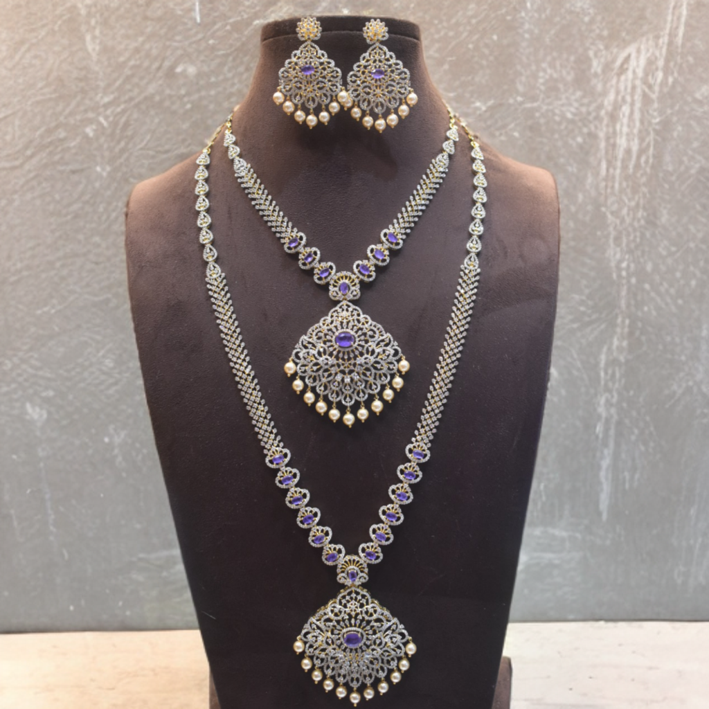 Silver necklace and earrings set on a black mannequin against a gray background