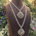 Ornate necklace on a mannequin with a floral background