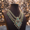 Ornate necklace with gemstones on a mannequin against a blurred background