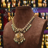 Decorative necklace on a brown mannequin with a blurred jewelry store background