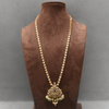 Gold necklace with a pendant on a brown velvet mannequin against a gray background