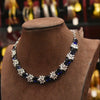 Necklace with blue and white floral beads on a brown velvet stand.