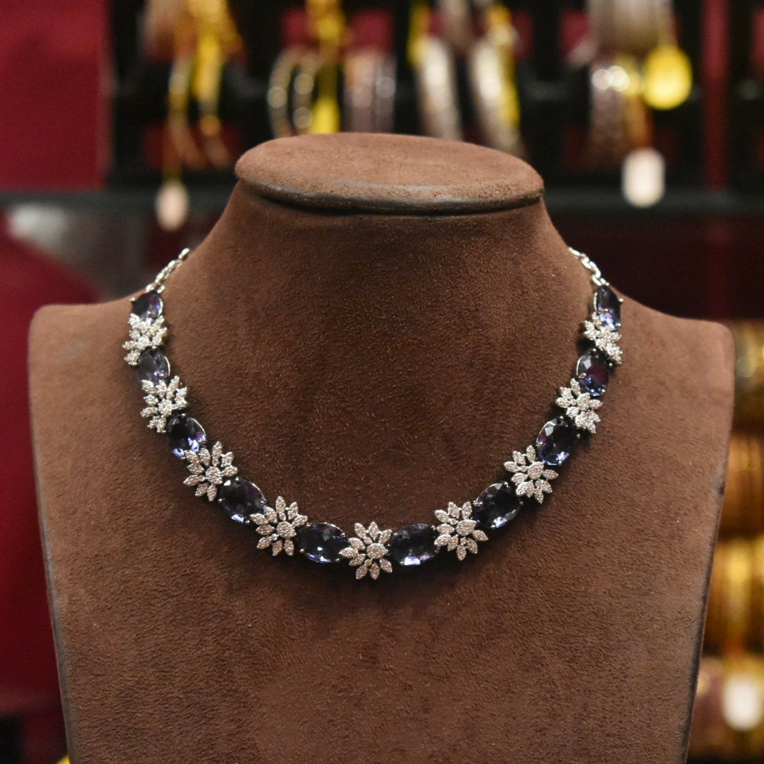 Necklace with floral designs on a brown mannequin bust against a blurred jewelry store background.