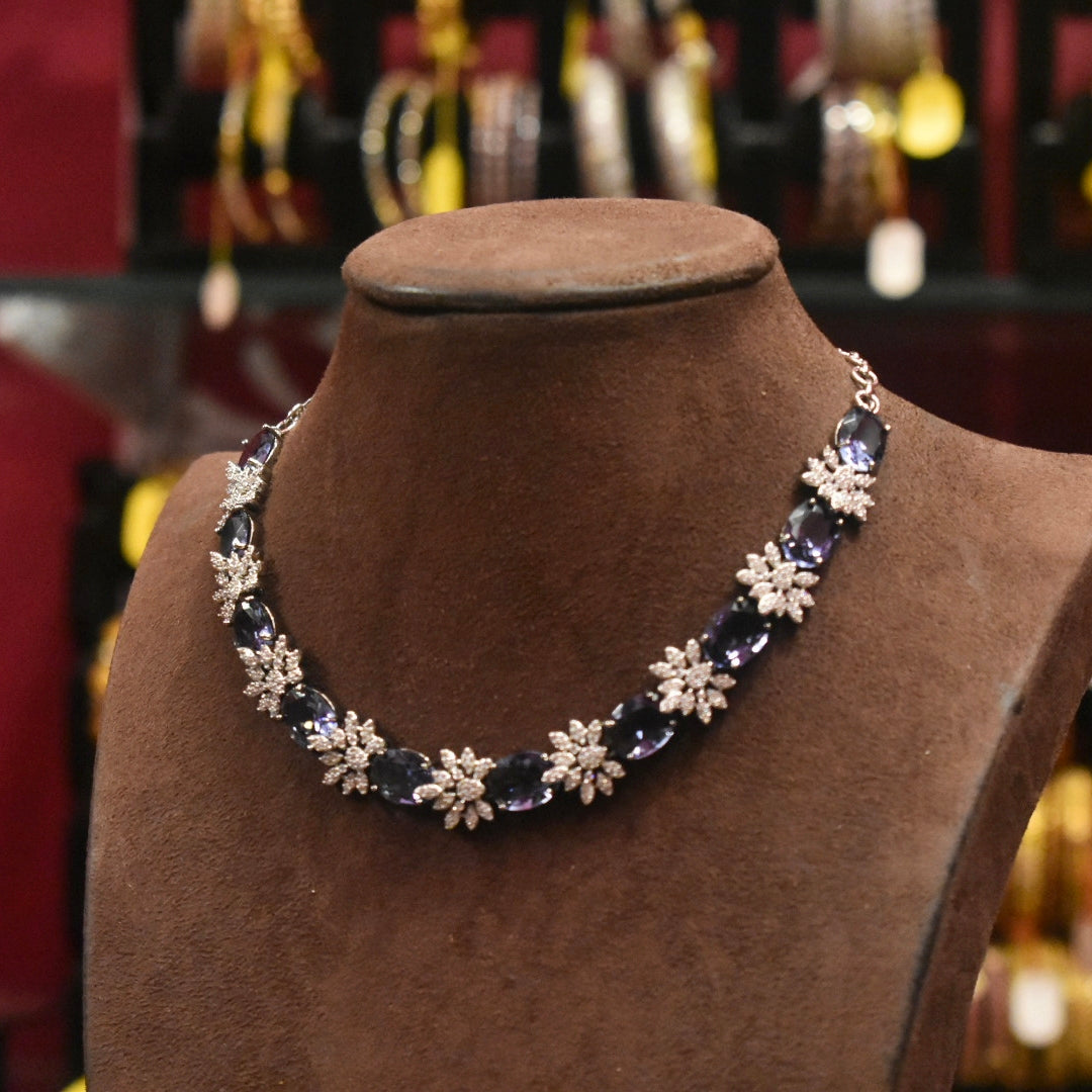 Necklace with floral designs on a brown mannequin bust with blurred jewelry store background