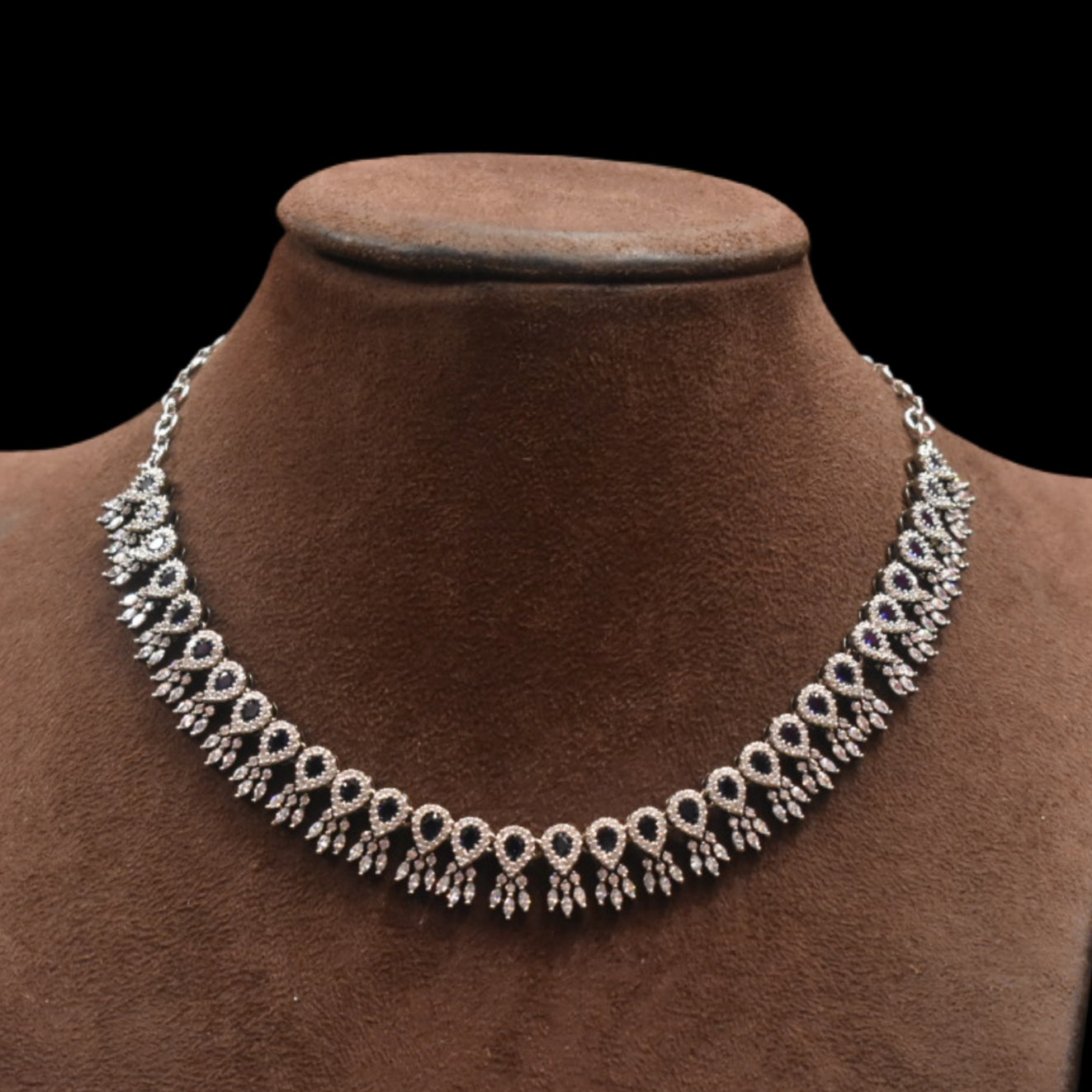 Necklace on a brown velvet mannequin against a black background