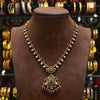 Decorative necklace on a brown mannequin with a blurred background of jewelry.