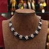 Necklace with blue and white floral beads on a brown velvet stand.