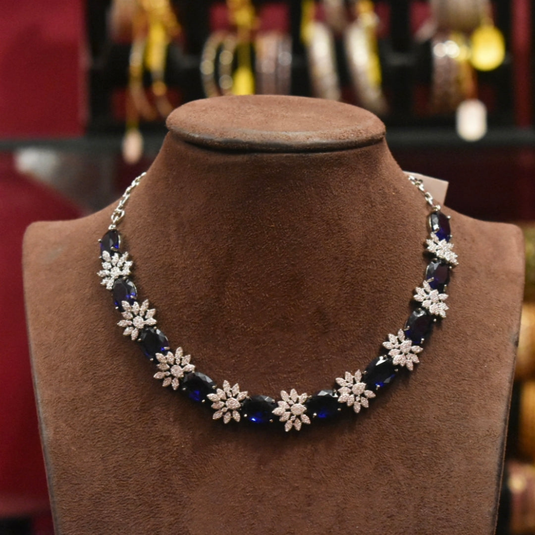 Necklace with blue and white floral beads on a brown velvet stand.