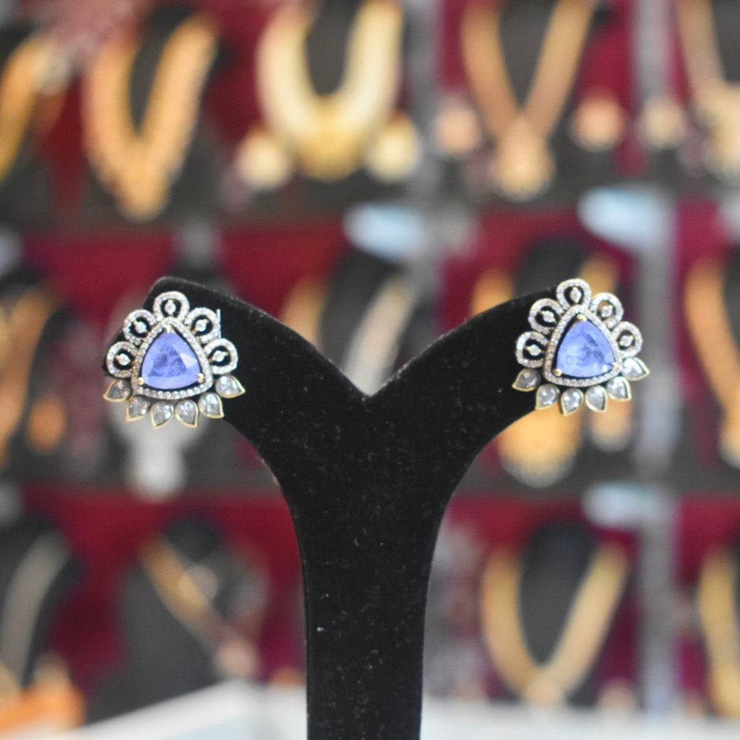 Pair of earrings on a black stand with a blurred background