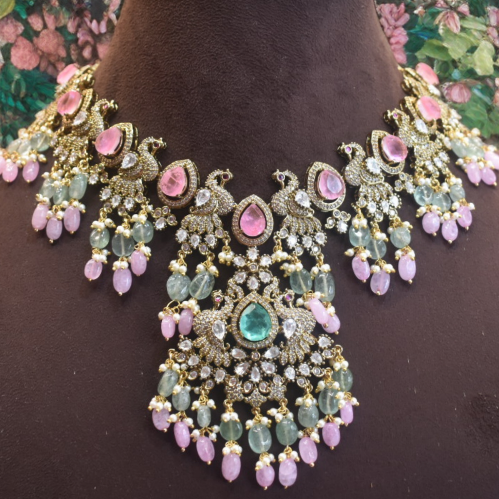 Ornate necklace with pink and green stones on a dark background