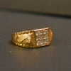 Gold ring with diamond accents on a dark surface