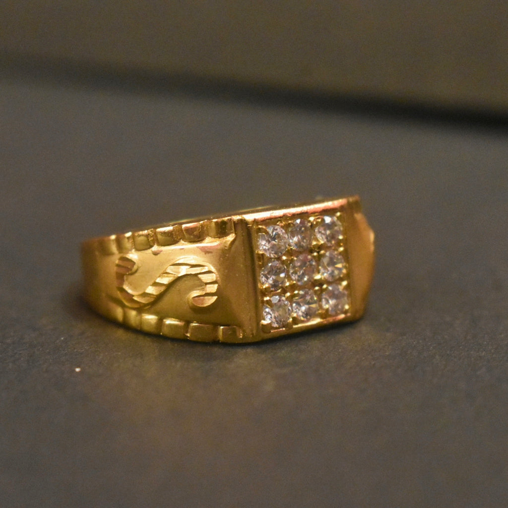 Gold ring with diamond accents on a dark surface