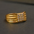 Gold ring with diamond accents on a dark surface