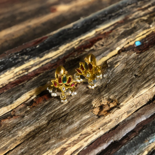 Gold earrings with gemstones on a wooden surface
