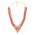 Coral red multi-strand beaded necklace with crystal centerpiece on white background
