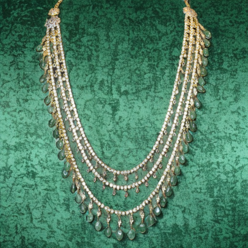 Delicate necklace with multiple strands on a textured green background