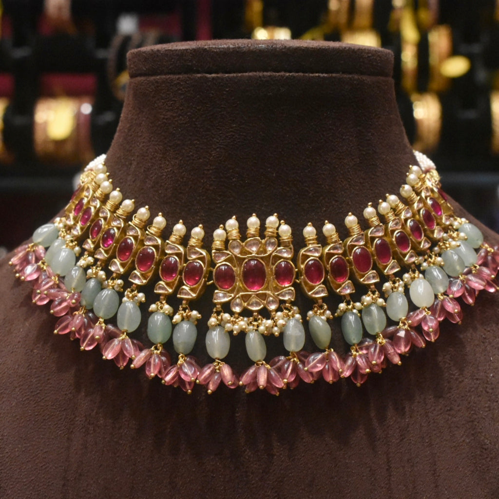 Ornate necklace with gemstones on a brown velvet stand