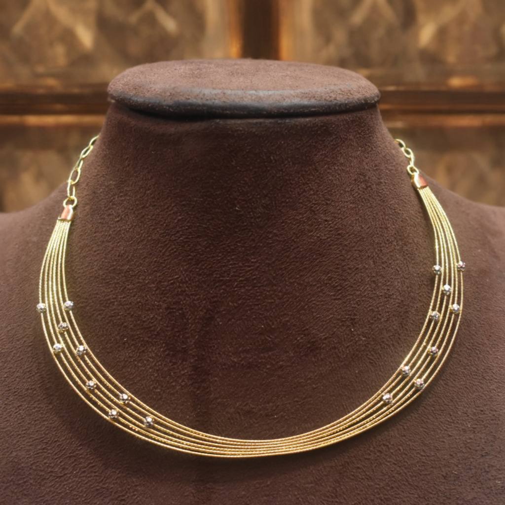 Gold necklace on a brown velvet mannequin with a gold background