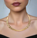 Gold necklace worn by a model with a blurred background