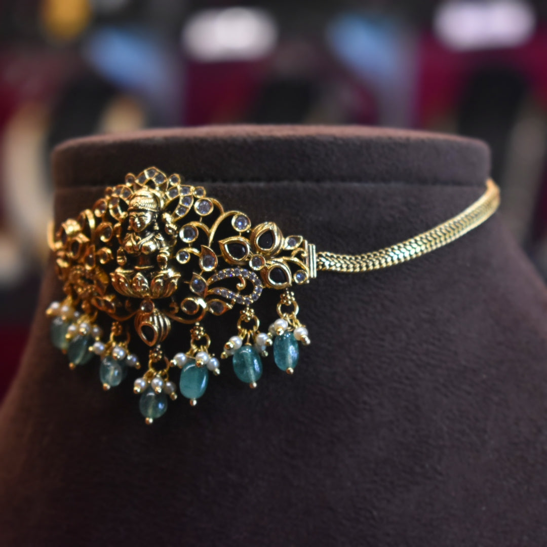 Gold and turquoise beaded headpiece on a dark brown mannequin head