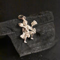 A silver pendant depicting the figure of Hanuman, symbolizing strength and protection.