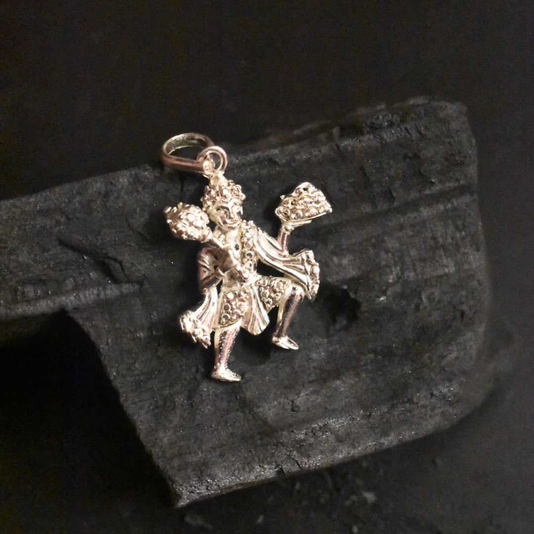 A silver pendant depicting the figure of Hanuman, symbolizing strength and protection.