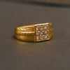 Gold ring with diamond accents on a dark gray background