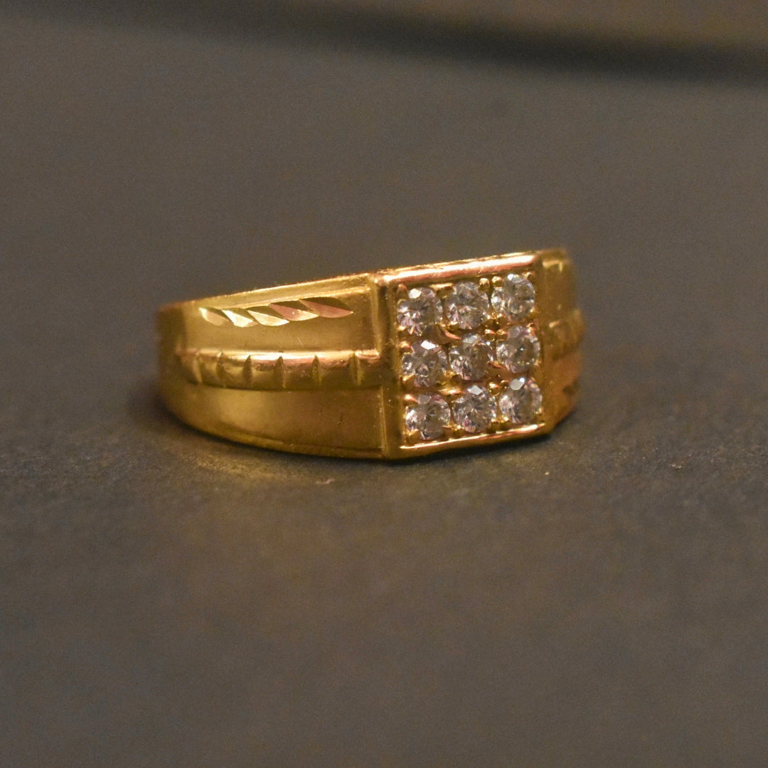 Gold ring with diamond accents on a dark gray background