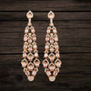 Pair of chandelier earrings with pink gemstones on a dark wooden background