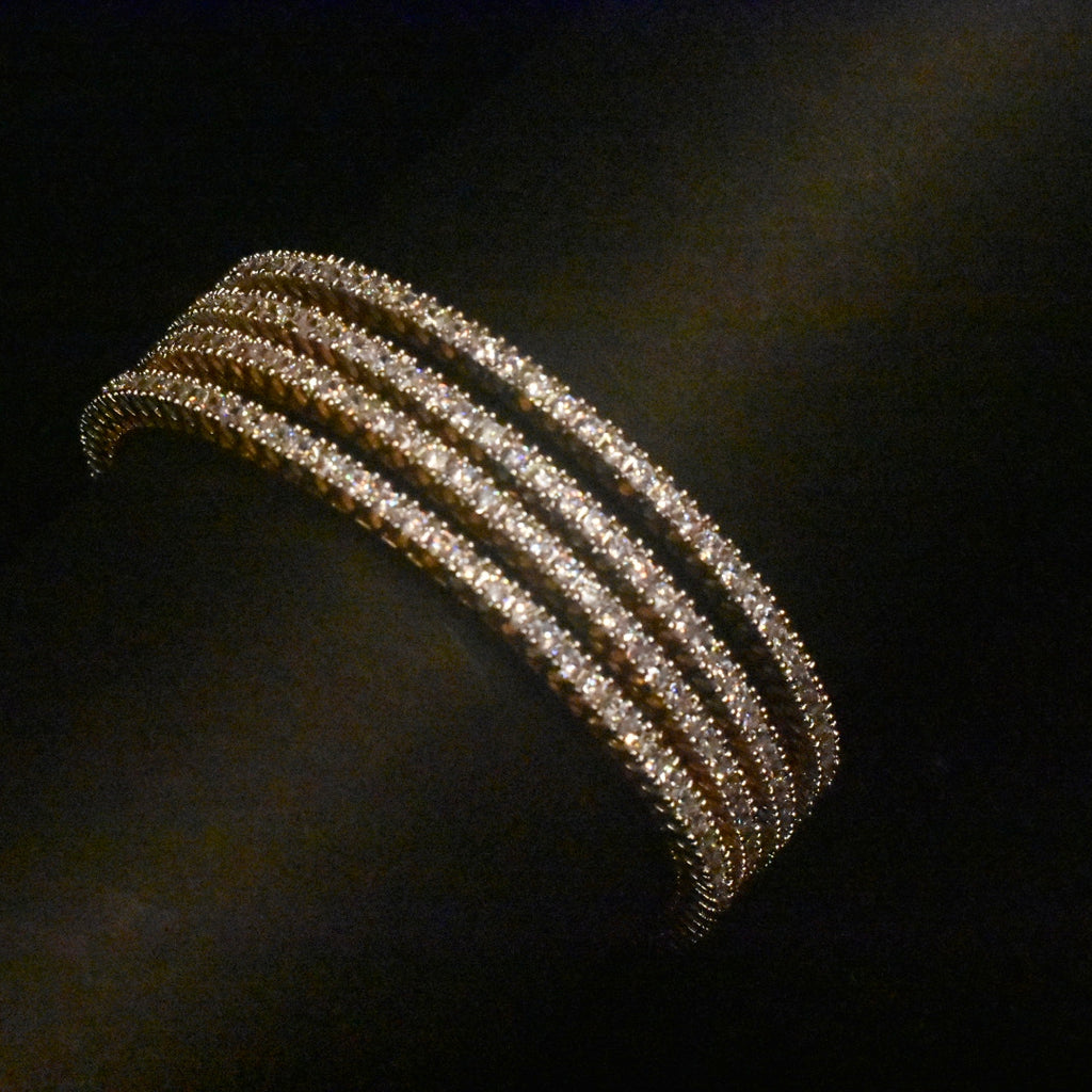 Gold bracelet with multiple rows of diamonds on a dark background