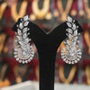 Pair of silver earrings on a black stand with a blurred background