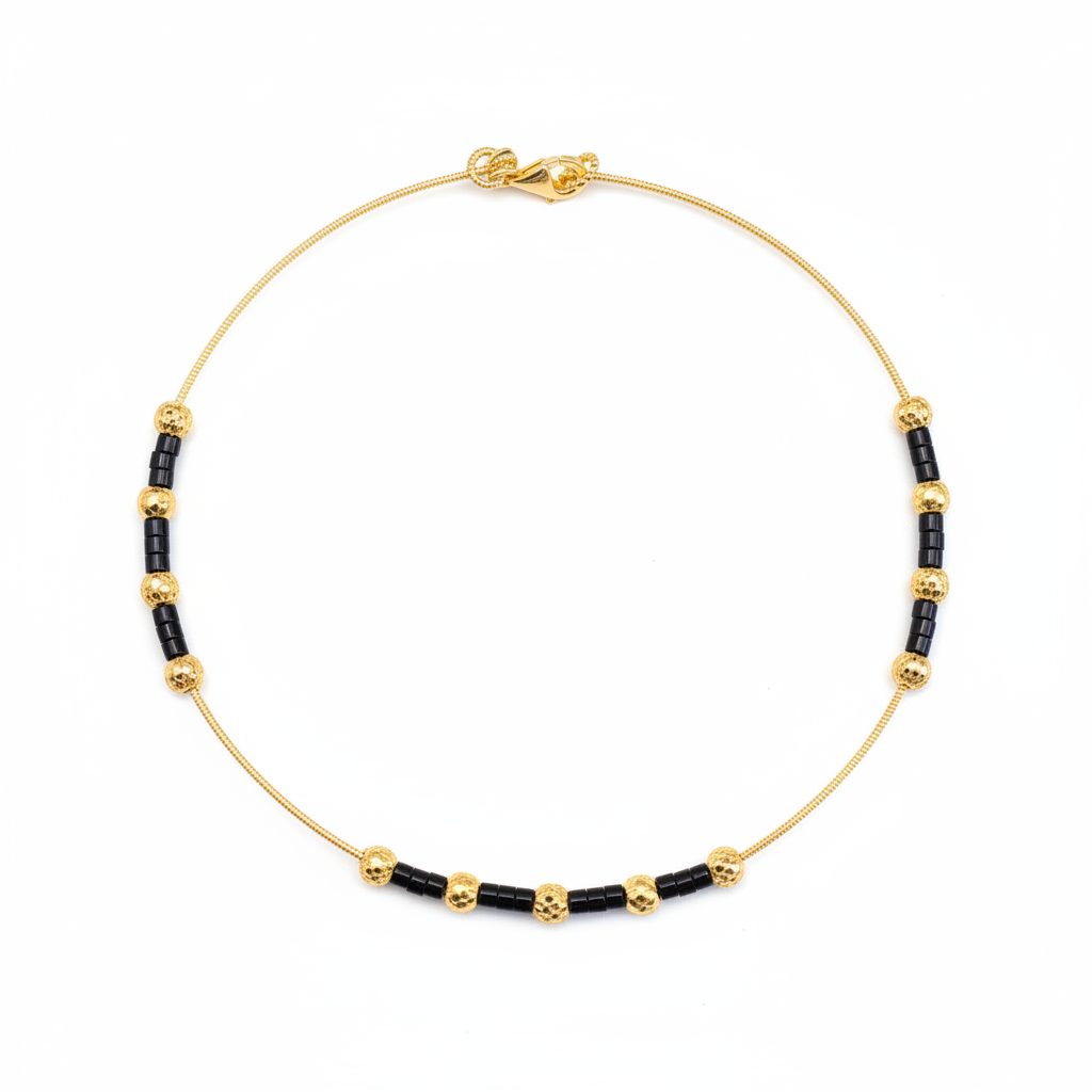 Gold and black beaded necklace on white background