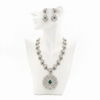 Emerald and diamond peacock necklace set displayed on mannequin