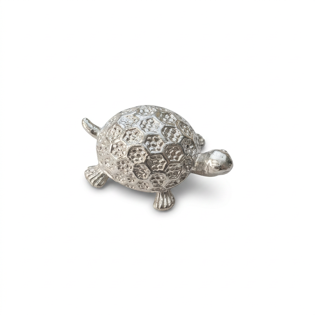 Silver-tone turtle figurine with a patterned domed shell on a white background