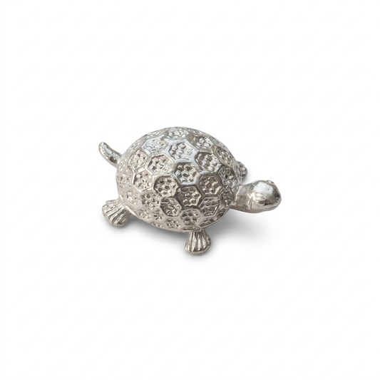 Silver-tone turtle figurine with a patterned domed shell on a white background